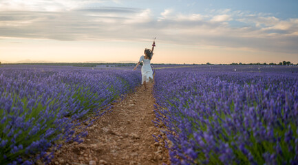 outdoors romantic portrait of young happy and attractive woman in white summer dress enjoying...