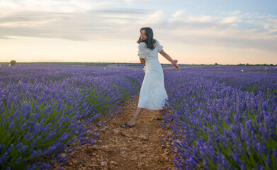 outdoors romantic portrait of young happy and attractive woman in white summer dress enjoying...