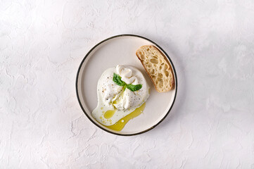 Italian burrata cheese with ciabatta bread and olive oil on white plate. Top view, copy space - obrazy, fototapety, plakaty