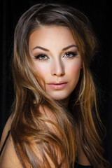 Fototapeta premium Natural beauty, skincare and haircare. Portrait of beautiful female model with clean face isolated on black background. Young woman shows healthy sensitive skin after using cosmetics and makeup