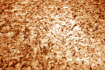 Granite surface as background with blur effect in orange tone.