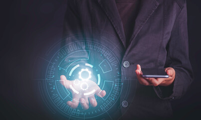 Digital workflow, Digital transformation, Automatic technology concept. Businessman holding digital machine gears  icons in cyber circle and holding smartphone.