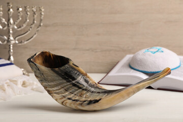 Shofar, Torah and kippah with Star of David on white wooden table. Rosh Hashanah holiday symbols
