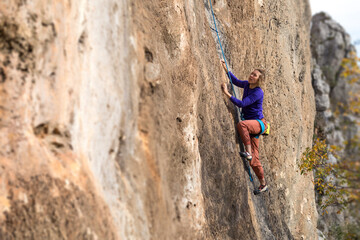Fototapeta premium girl climbs a rock-climbing route. outdoor sports.