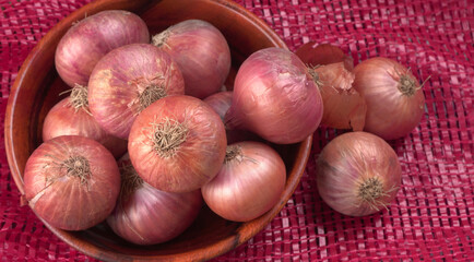 Fresh red onions in a wooden bowl.