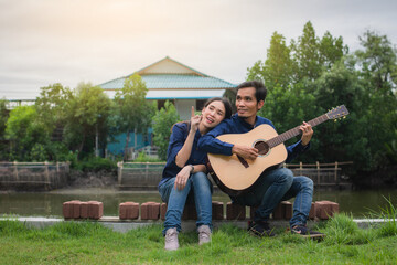 Asian Couple playing guitar rest in summer