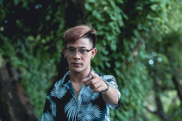 A young fashionable man in a tropical polo shirt demands for answers. With a stern facial...