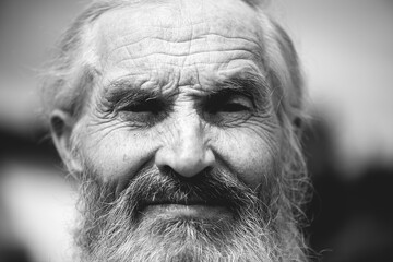 Close - up of  wrinkled face of old senior man portrait with white hair and a white beard, black and white