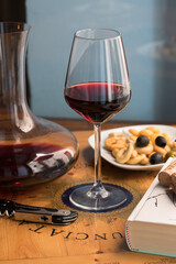 a glass of red wine and decanter