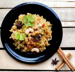 Indian Traditional dish Vegetable Rice or Pulao or vegetable briyani made with Basmati rice, Vegetables and spices isolated in a wooden background with selective focus and copy space. Indian cuisine. 
