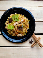 Indian Traditional dish Vegetable Rice or Pulao or vegetable briyani made with Basmati rice, Vegetables and spices isolated in a wooden background with selective focus and copy space. Indian cuisine. 