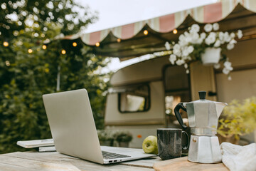 Inspirational and creative workplace for remote work, laptop on wooden table. Mobile home and nature on background. Technology, remote job, freelance, work from any place concept
