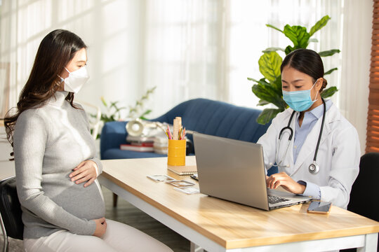 Professional Asian Doctor Woman Consulting Pregnant Patient,Smart Doctor Wearing White Coat With Stethoscope Talking To Patient At Hospital,Doctor And Pregnancy Patient Concept