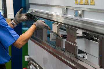 The technician operator working with hydraulic press brake bending machine.