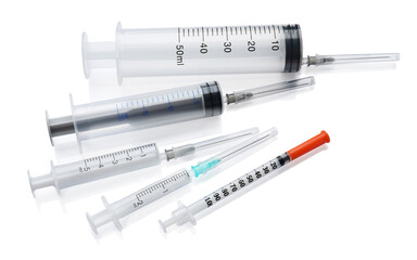 Different disposable syringes with needles on white background