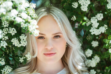 Portrait of a young beautiful woman in a blooming garden. Spring.