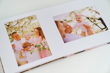 Fototapeta na wymiar white background open photobook from family photo shoot in spring garden