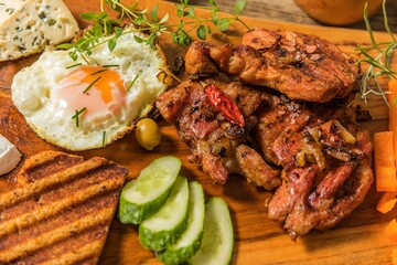 Grilled meat with fried egg and cheese. Summer barbecue. Fat meal.