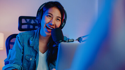 Happy asia girl host record podcast use microphone wear headphone with laptop interview guest...
