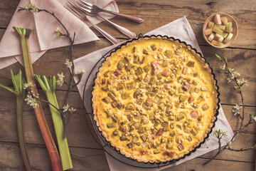 Homemade rhubarb pie and spring decoration on rustic wooden background
