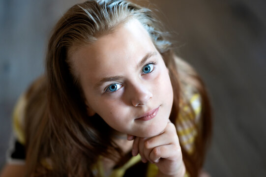 Close-up of pretty teenage girl face with blue eyes looking at camera