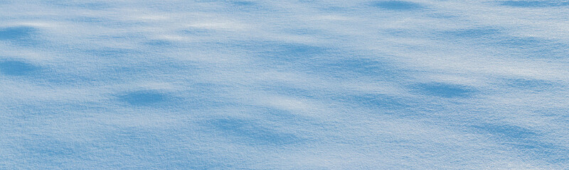Snowy background, snowy surface with a clearly expressed texture of snow in the morning sun
