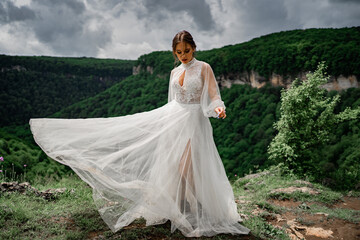 woman in a wedding dress posing in the mountains. fashionable clothes for bride