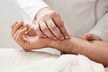 Obraz na płótnie Canvas Reflexologist insert acupuncture needle into a patient's hand. Acupuncture treatment, reflexology, alternative medicine