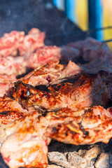 Meat on skewers is fried on coals with smoke
