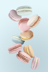 Sweet delicious macarons flying on light blue background