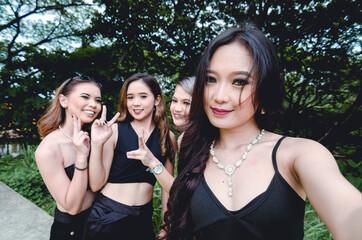 Four friends in black goth outfits pose for a fun groufie. Happy partygoers having a great time...