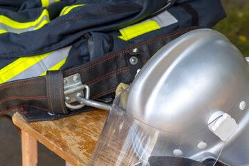 Firefighter uniform with red helmet. Close-up image of a red helmet of a fireman. A  helmet of the firefighter . Close-up shot elements of regimentals of the rescuer
