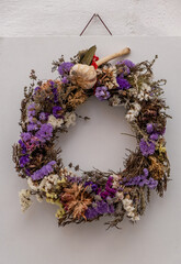 Dry flowers wreath hanging on whiteboard at Paros island Naoussa village Cyclades Greece. Vertical