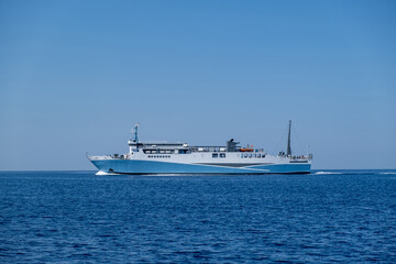 Fototapeta na wymiar Ferryboat in blue Aegean sea and sky background. Greek island. Greece
