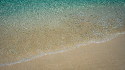 Fototapeta na wymiar clear blue ocean waves on the beach There is a smooth sandy beach.