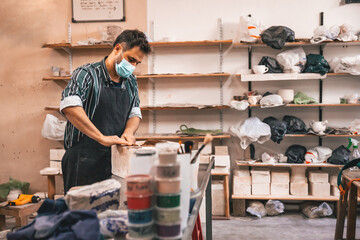 young adult potter molding with clay to make a piece of ceramic
