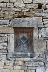 old stone wall with vintage shutter and tiny window