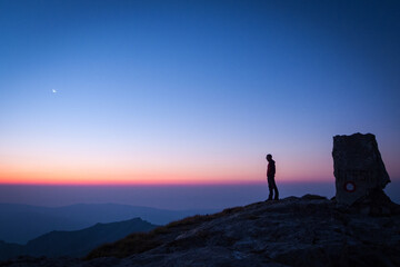 Fototapeta premium Man Observing Dawn at Korab Peak, Northern Macedonia