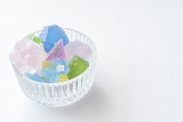 Fototapeta na wymiar 光が透過して透明感のある色とりどりの琥珀糖　カラフルな宝石　キラキラ