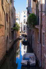 Fototapeta na wymiar romantic idyllic view of boats moored in narrow canal of Venice