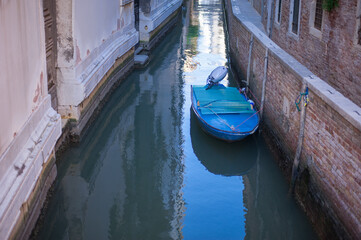 Fototapeta na wymiar romantic idyllic view of boats moored in narrow canal of Venice