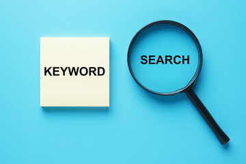 Keyword on notepad with magnifying glass written search. Search the keyword.