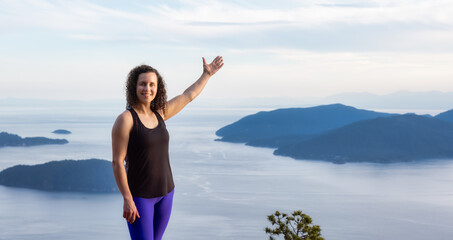 Adventurous Caucasian Adult Woman hiking on top of a mountain during a colorful sunny summer day....