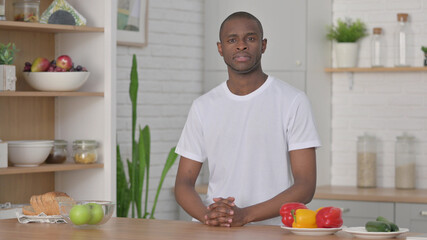 African Man Looking at the Camera while Standing in Kitchen