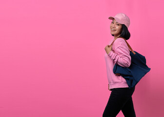 Portrait of happy young Asian woman holding bag while shopping