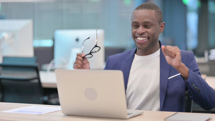 Successful Young African Businessman with Laptop Dancing at Work