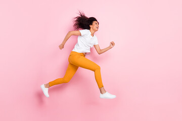 Photo of pretty charming dark skin woman dressed white outfit jumping high running fast empty space isolated pink color background