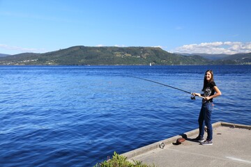 Woman fishing in Salhusfjorden, Norway
