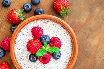 Chia seed pudding made with fruits and fresh  berries over wood background. Chia seeds Yogurt.