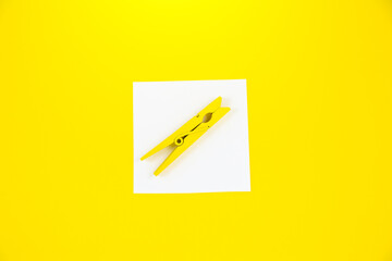 Blank white To Do List Sticker with yellow wooden clothespin. Close up of reminder note paper on...